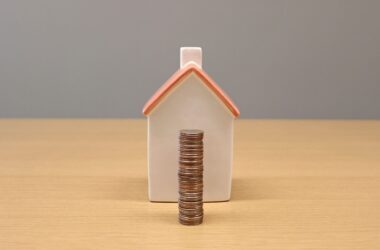 service-1 A conceptual still life image of stacked coins in front of a porcelain house, symbolizing savings and investment.