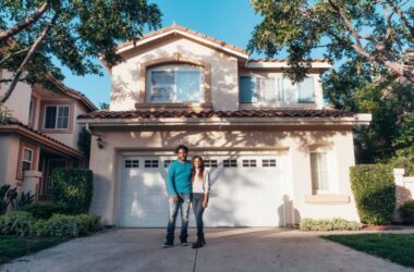 service-1 Smiling couple standing outside their newly purchased house on a sunny day.